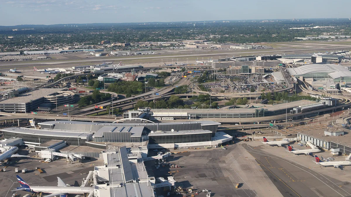 Aerial view of JFK Airport, showing terminals and airplanes below.