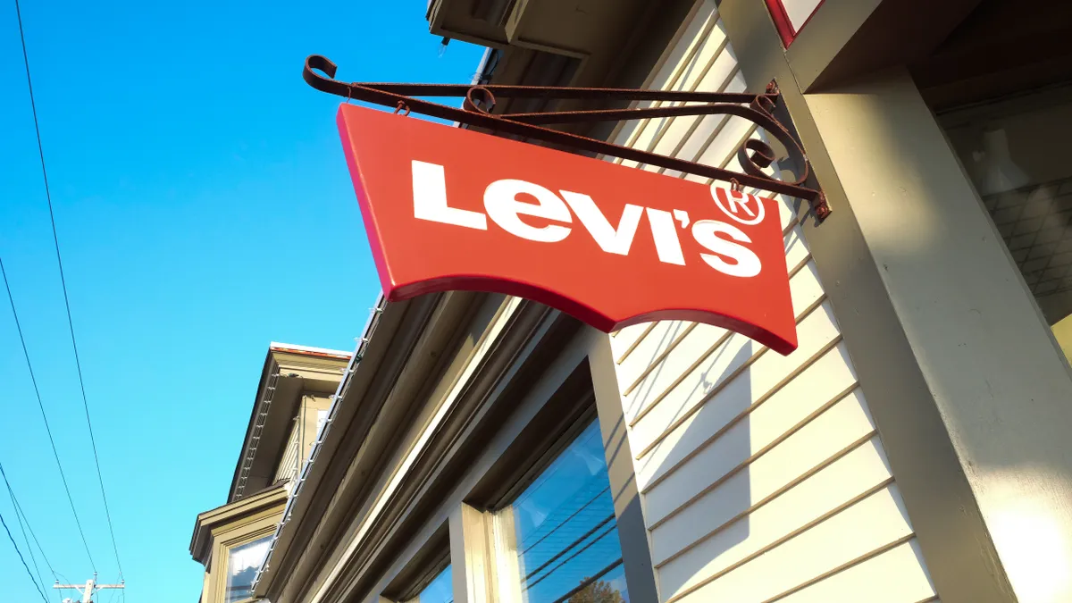 A red Levi's tab sign against a bright blue sky.