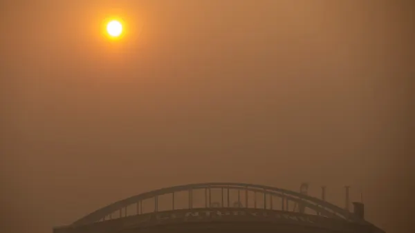 A stadium surrounded by orange, smoke-filled sky.