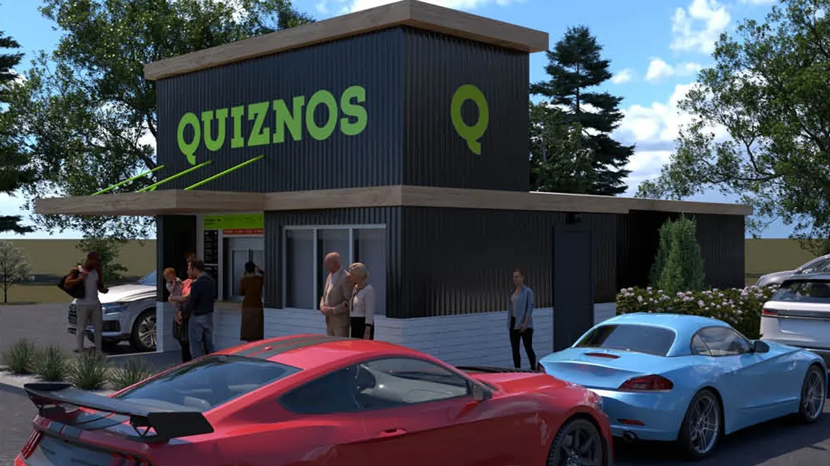 An image of a small gray building with green Quiznos wording on the side.