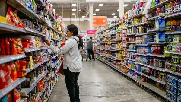 A customer examines a product in a grocery aisle.