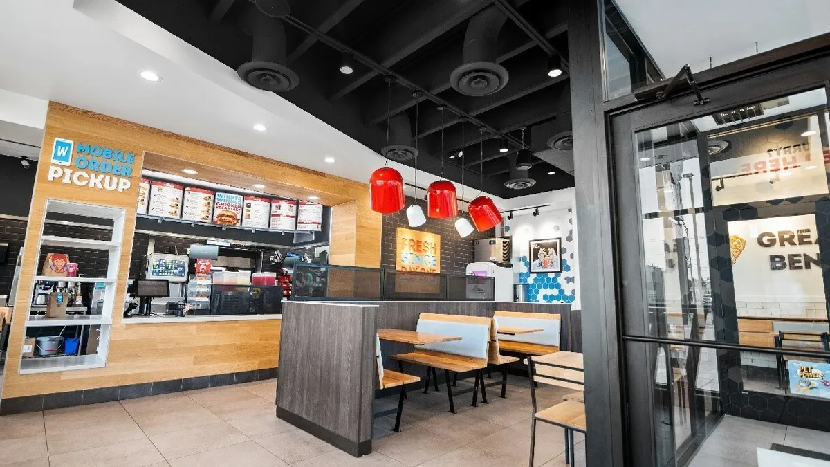 An image of the inside of a Wendy's restaurant with mobile pick up windows and some seating.