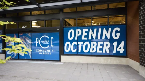 Signs over grocery store window indicating it will open on Oct. 14