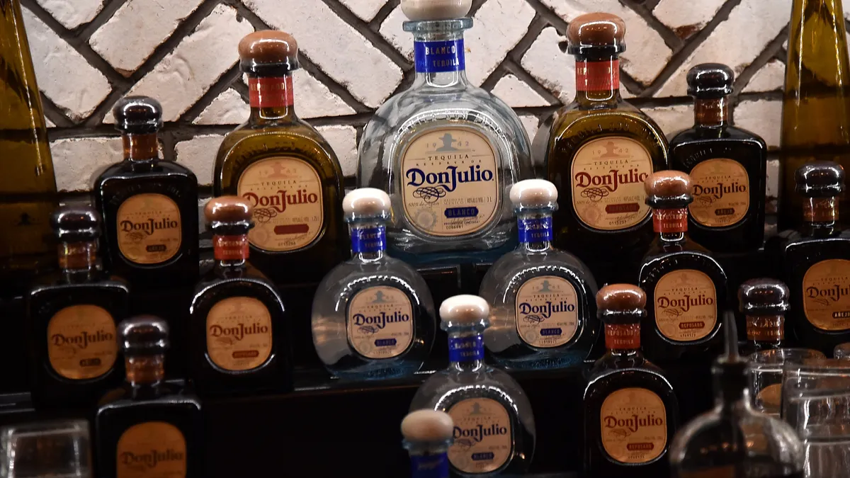 Bottles of Don Julio line several bar shelves.