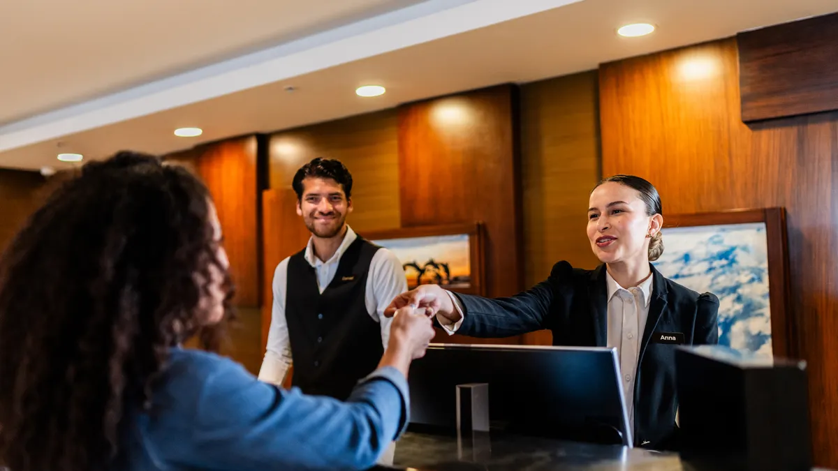 A hotel receptionist checking in guests at the front desk