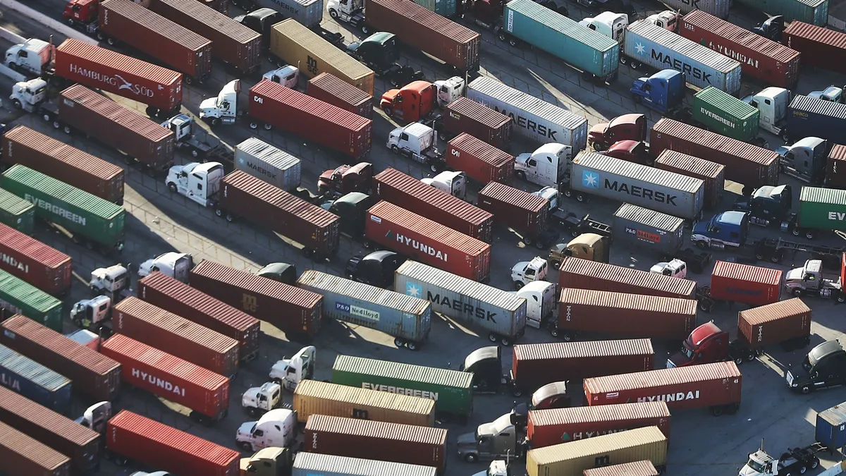 Trucks wait at a gate outside a Port of Los Angeles terminal.