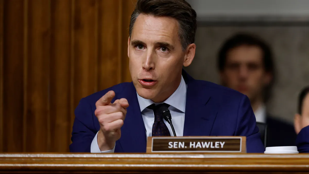 Senator Josh Hawley points his figure toward the during questioning from a perch on the chamber's raised platform.