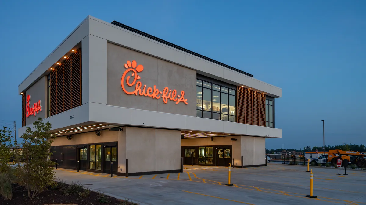 A drive-thru Chick-fil-A consisting of a kitchen suspended over four drive-thru lanes.