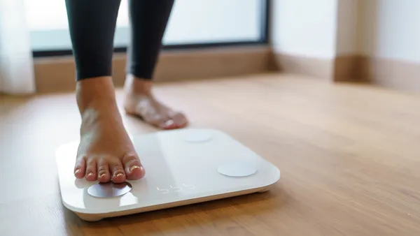 Woman about to stand on a weighing scale