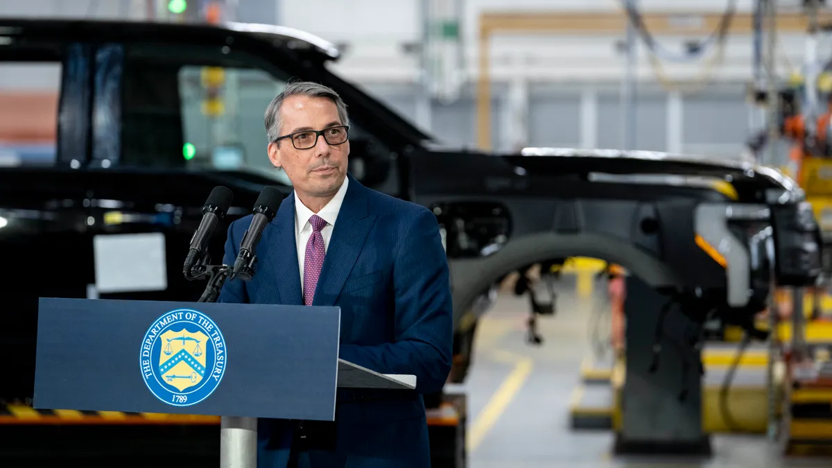 Ford CFO John Lawler speaks at a podium during an event automaker's Rouge Electric Vehicle Center on Sept. 8, 2022 in Dearborn, Michigan.