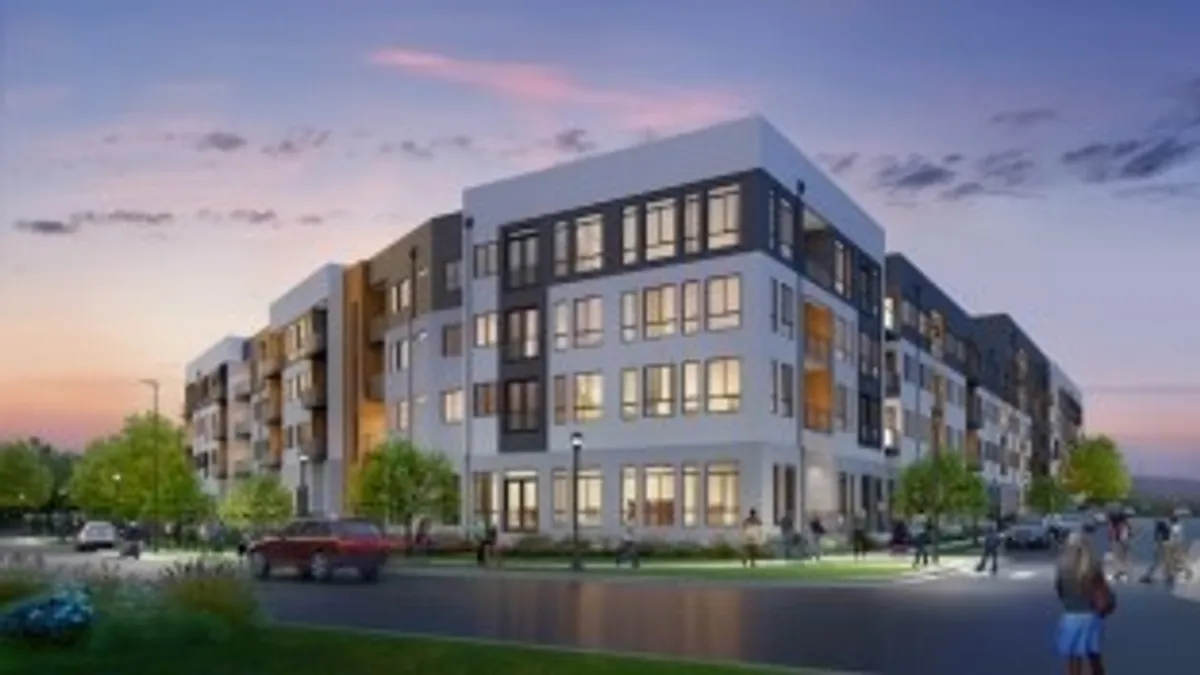 New, multi-colored, four-story apartment property, with a street in the foreground.