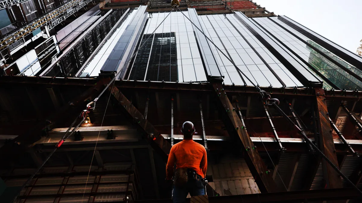 Construction workers prepare steel for a crane