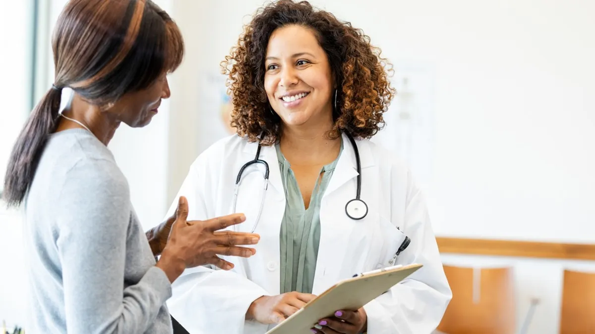 Female doctor and patient talking; healthcare, medicine, consultation.