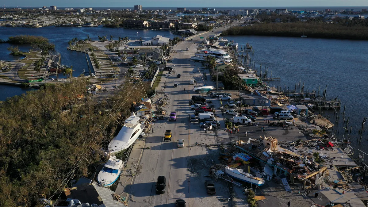 Aerial view of a bridge covered in debris, boats and cars.