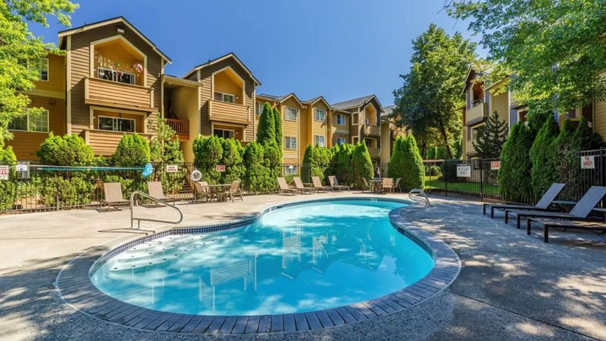 Three story apartments with a pool in the foreground