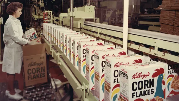 A Kellogg Company employee packs Kellogg’s Corn Flakes cartons on a production line, circa 1966.