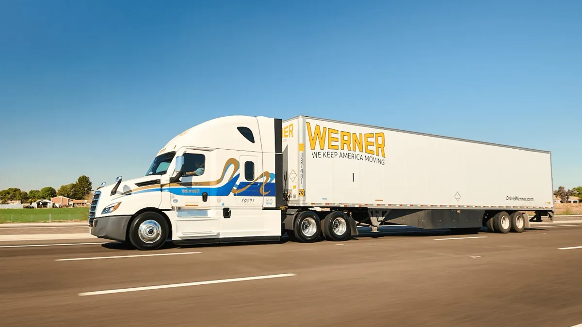 A freight truck with the Werner Enterprises logo on the road.