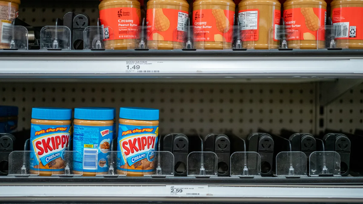 Jars of peanut butter on store shelves.