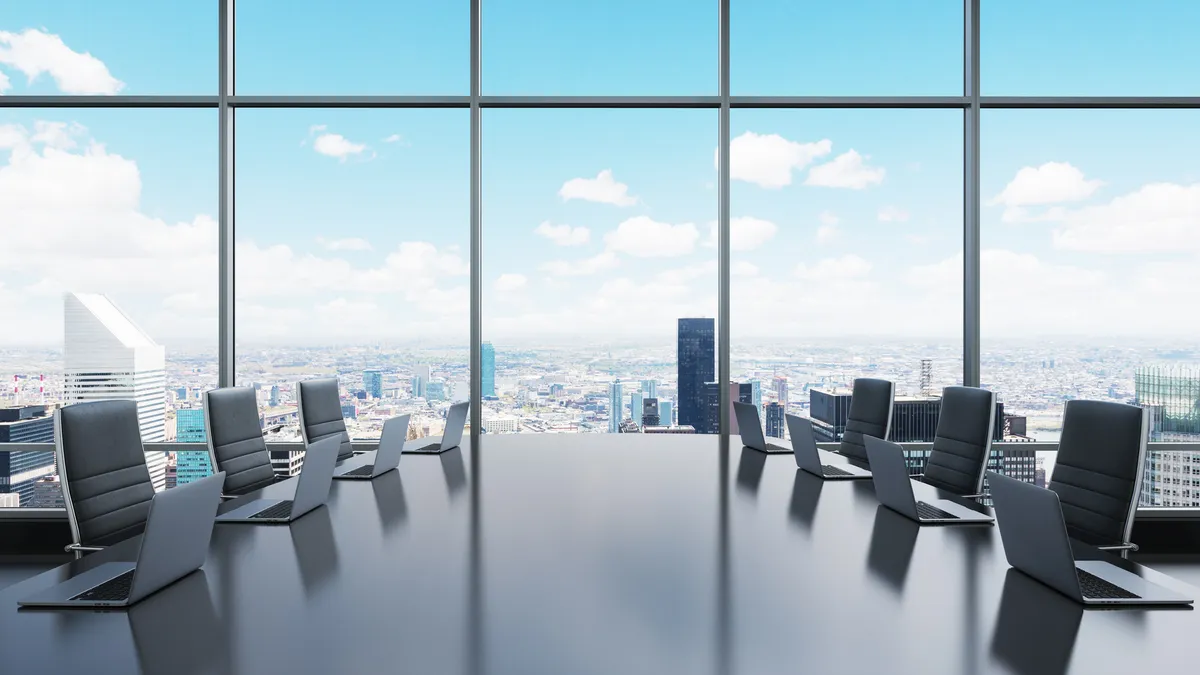 A conference room equipped with laptops in a modern panoramic office.