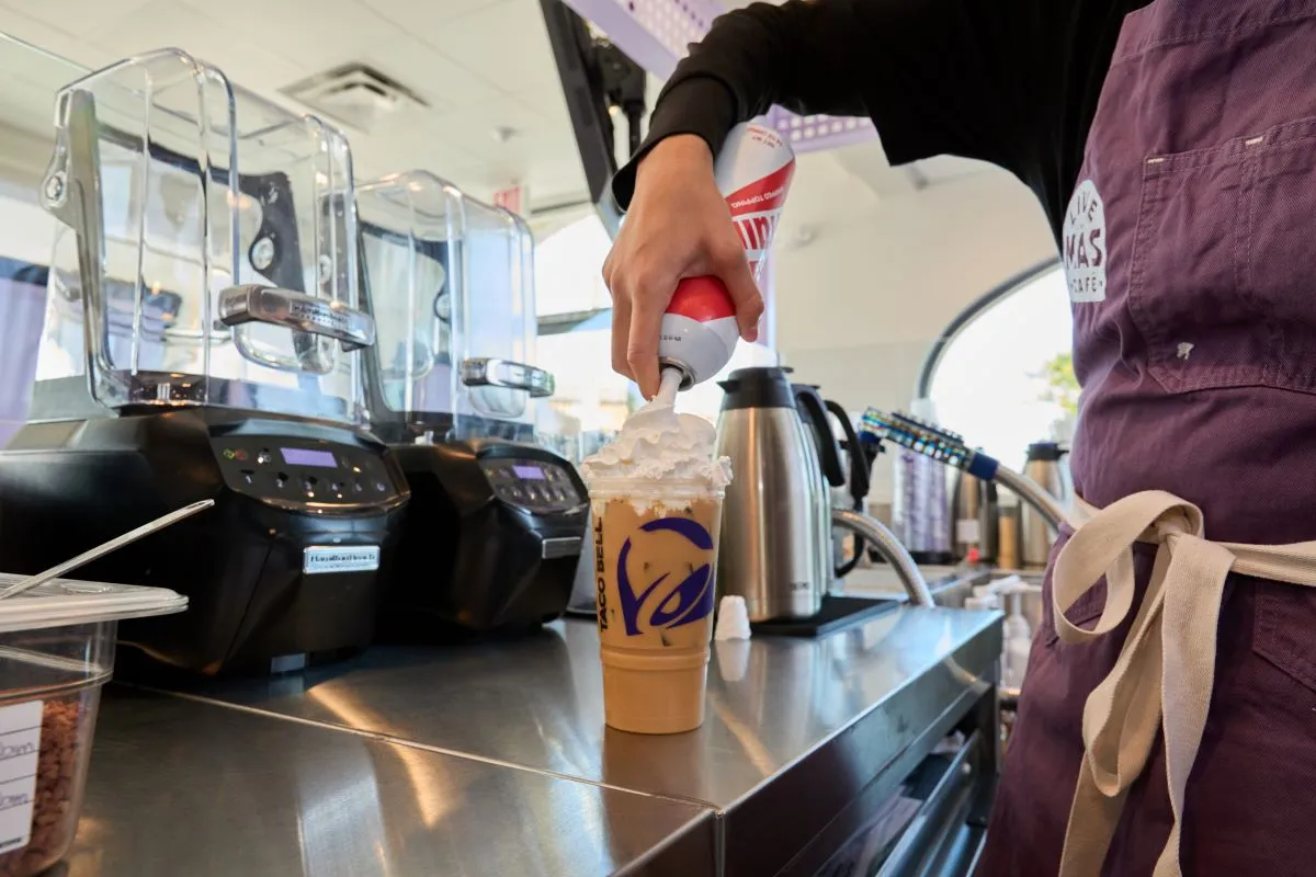 A worker prepares a specialty coffee drink inside a Taco Bell Live Mas Cafe