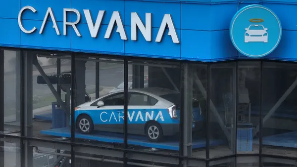 In an aerial view, a sign is posted on the exterior of a Carvana car vending machine on July 19, 2023 in Daly City, California.