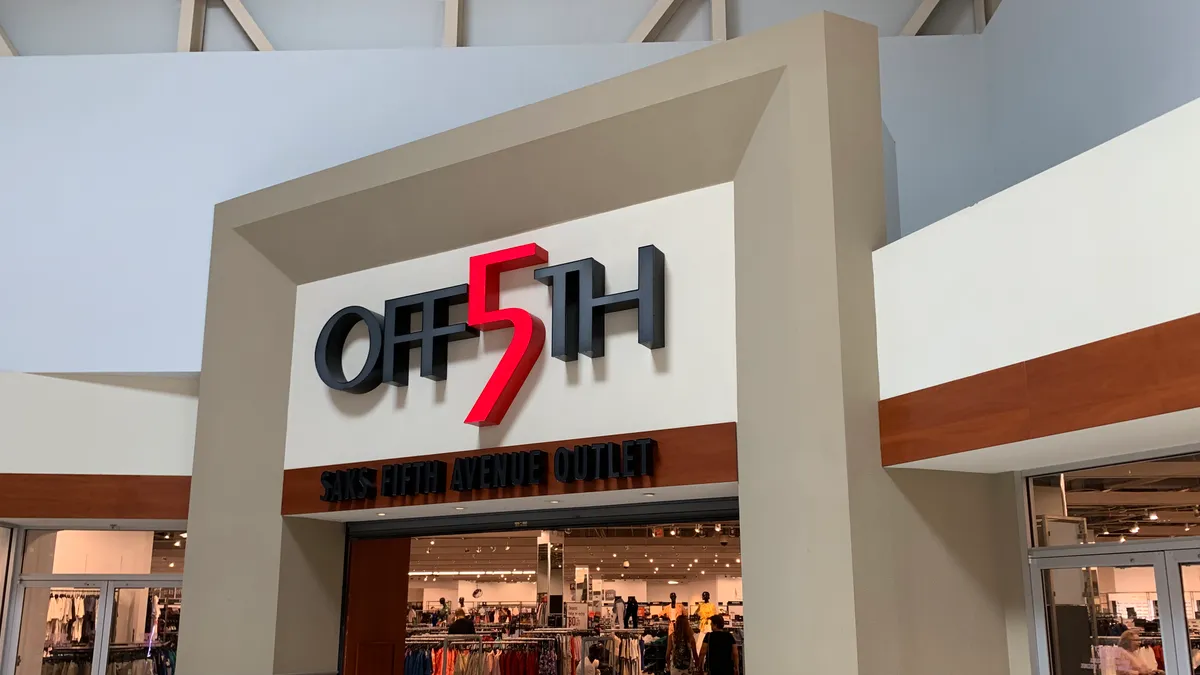 A mall entrance to a store whose sign says "OFF 5th" in black lettering and a red "5."