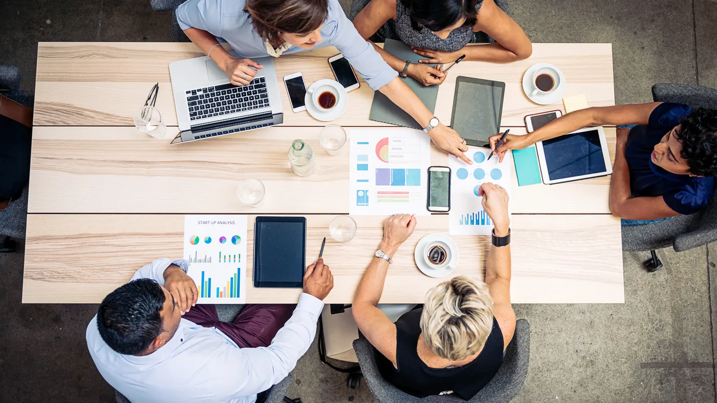 Group of business people sitting at the table and discussing business outcomes.