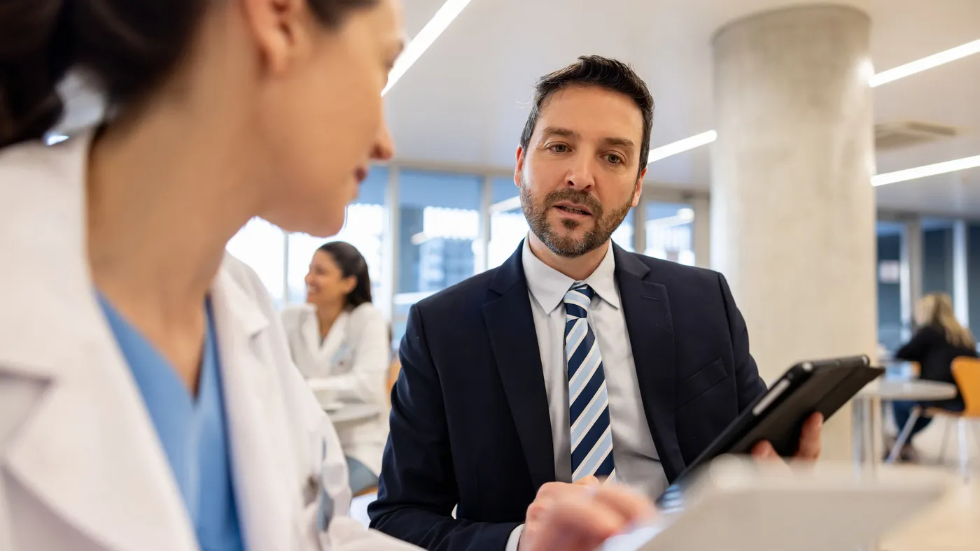 Hospital manager talking to a doctor and looking at a medical record