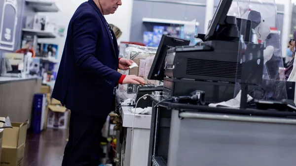 An employee uses a cash register.