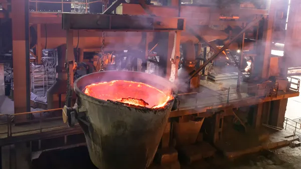 A large melting pot with molten metal in the factory.