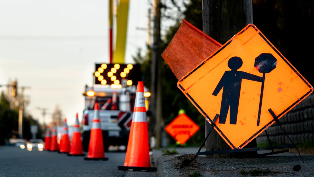 Cones and a sign blocking a lane off from traffic.