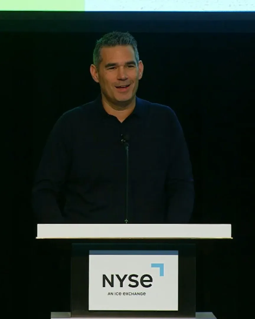 A man wearing a pullover stands at a podium