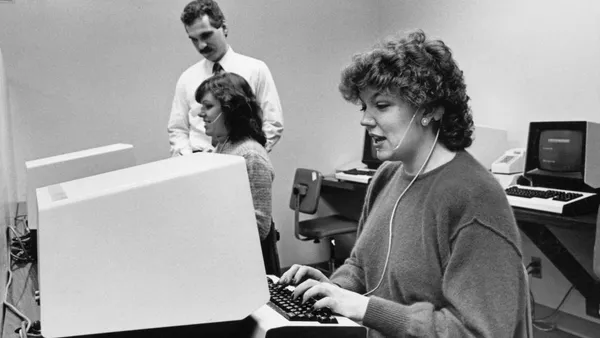 A woman in the 80s uses a computer.