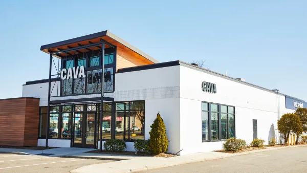 A white building with windows on the front with a large sign that says Cava