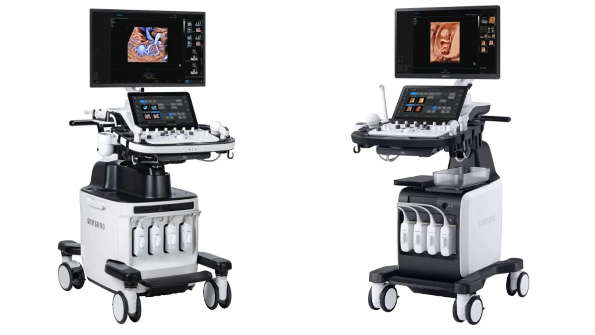 Two ultrasound machines on wheels with screens showing medical images are side by side.