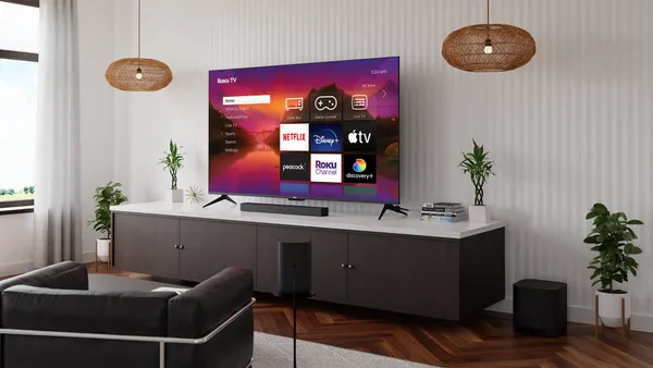 A television sits on top of a TV set in front of a couch.