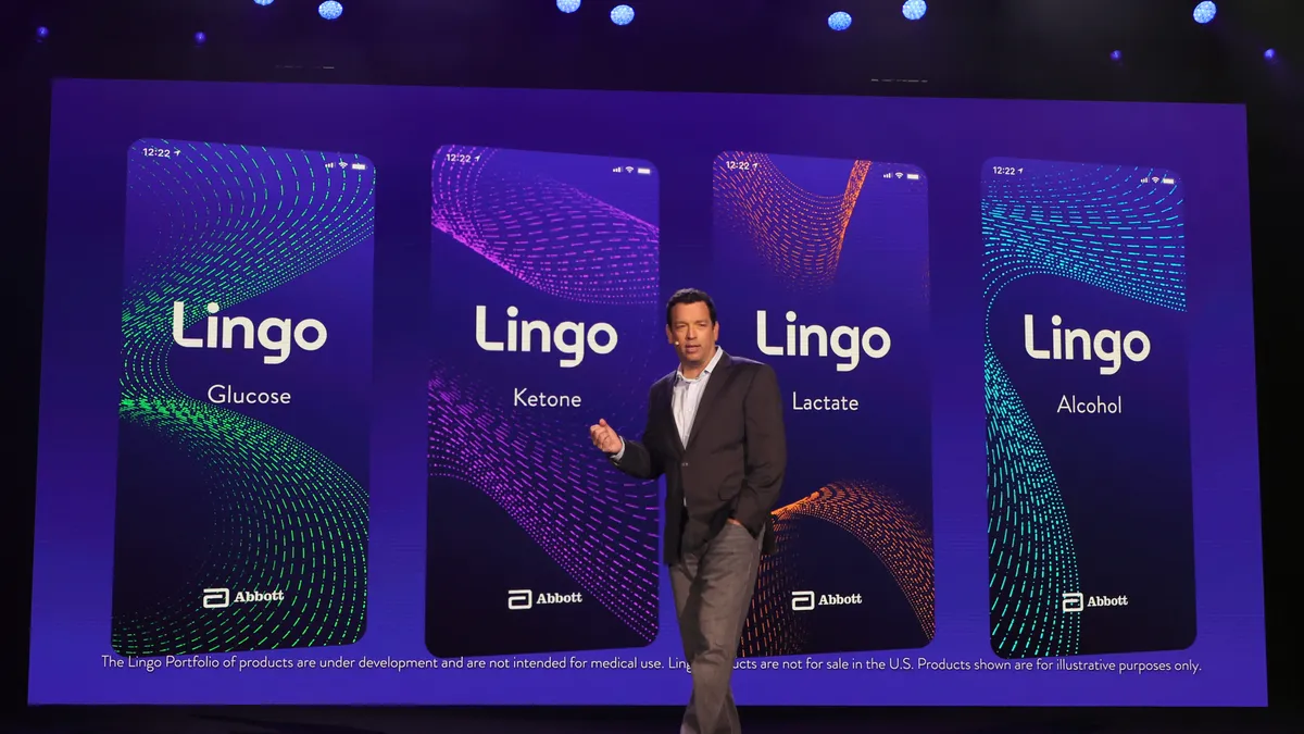 A person speaks in front of a screen showing four cards that read: Lingo Glucose, Lingo Ketone, Lingo Lactate and Lingo Alcohol