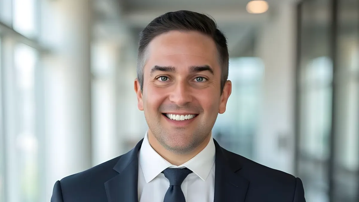 CMR Surgical's Chris O'Hara poses in a dark blue suit and tie.
