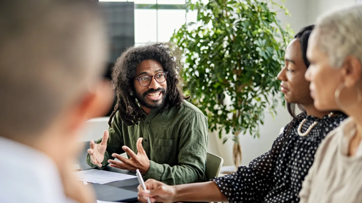 People in a meeting a person talking to everyone