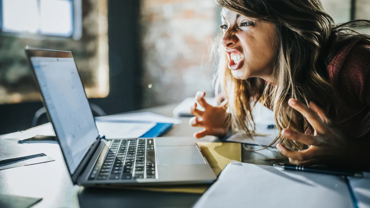 Frustrated woman looks at computer