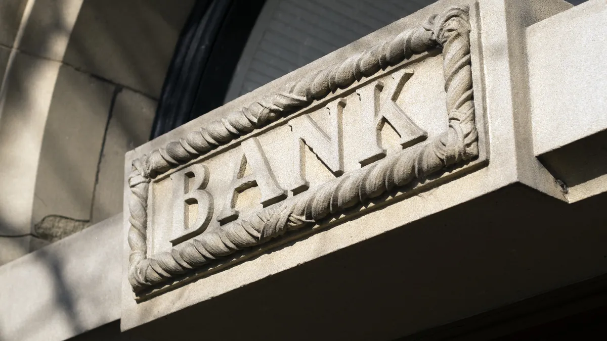 The word "bank" is engraved on a brick building.