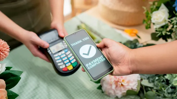 Close up of easy payment by credit card or smartphone application Greenhouse workers selling pottered flowers.