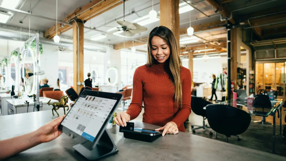 Women scratching card on card machine.