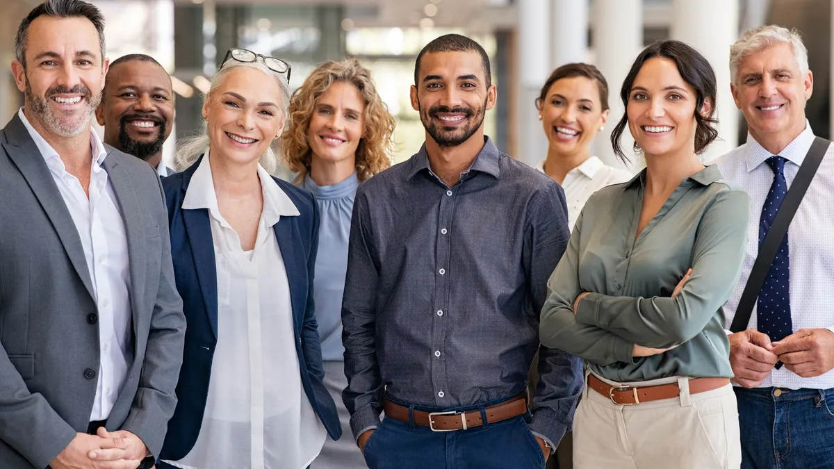 A group of business people standing next to each other in an office