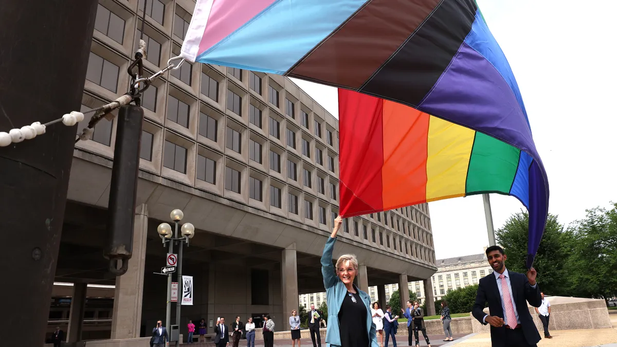 Energy Secretary Jennifer Granholm and former Chief of Staff Tarak Shah raise the Progress Pride Flag for the first time outside the Department of Energy in Washington, D.C.