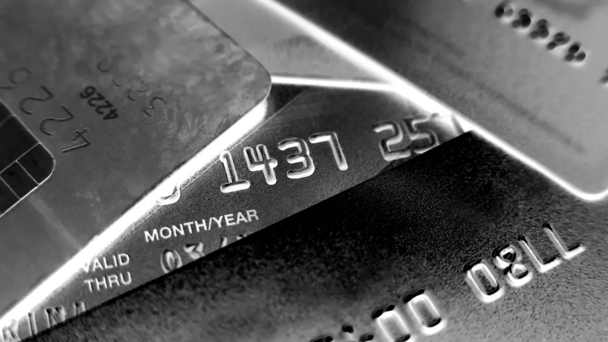 A black and white invert image of a pile of credit cards.