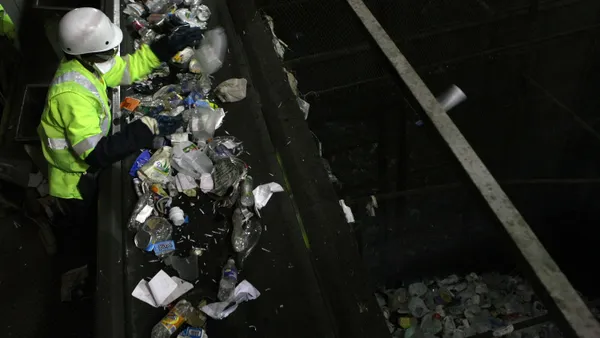 A worker sorts recycling at a MRF