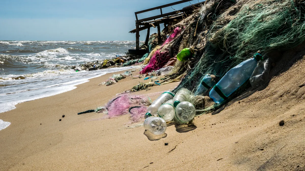 Plastic waste on a sandy beach. Pollution of the waters of the world ocean by plastic. Polluted beach in Los Angeles, USA