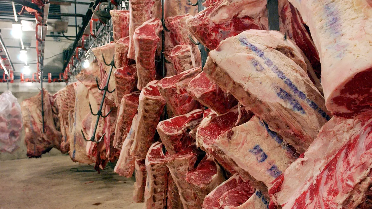 Beef hangs in a meat warehouse.