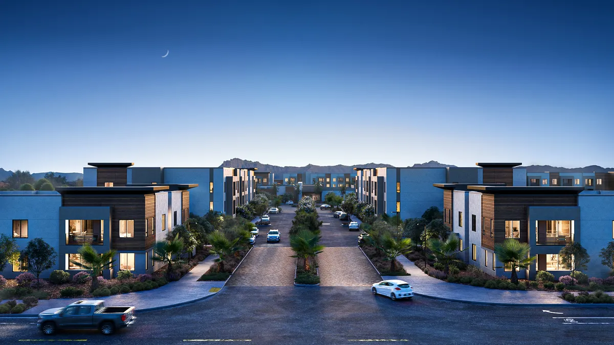 A two-story apartment property at dusk, surrounded by roads and cars.